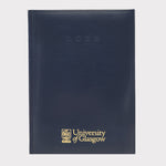 University of Glasgow Diary A5 Week to View. Navy faux leather, uni logo embossed in gold on centre bottom, 2026 embossed in navy top centre. 