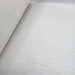 Close-up of lined notebook paper with a focus on texture and lines.