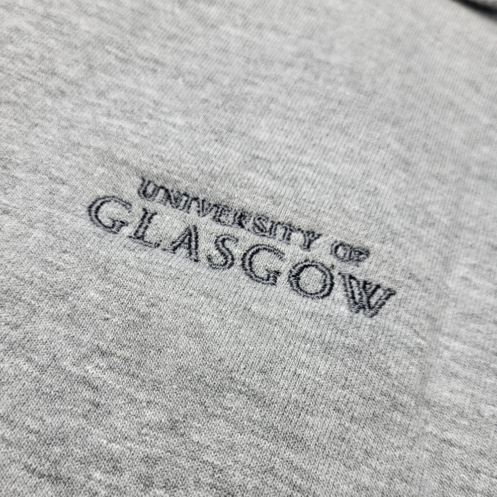 Embroidered 'University of Glasgow' logo on a gray fabric background