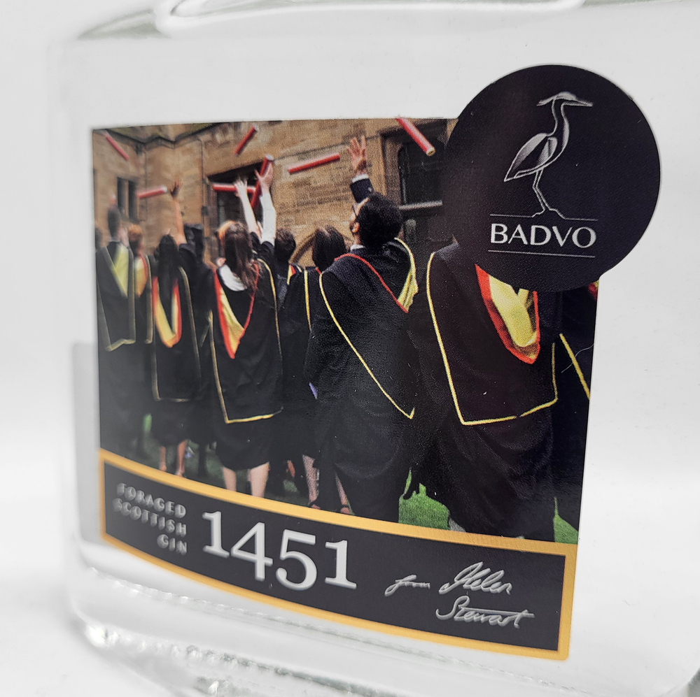 Alcohol bottle label with graduation scene and BADVO branding