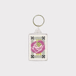 Keychain with cross-stitched design of a pink flower on a white background