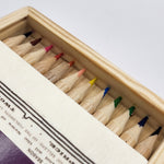 Set of colored pencils in a wooden box with a white background