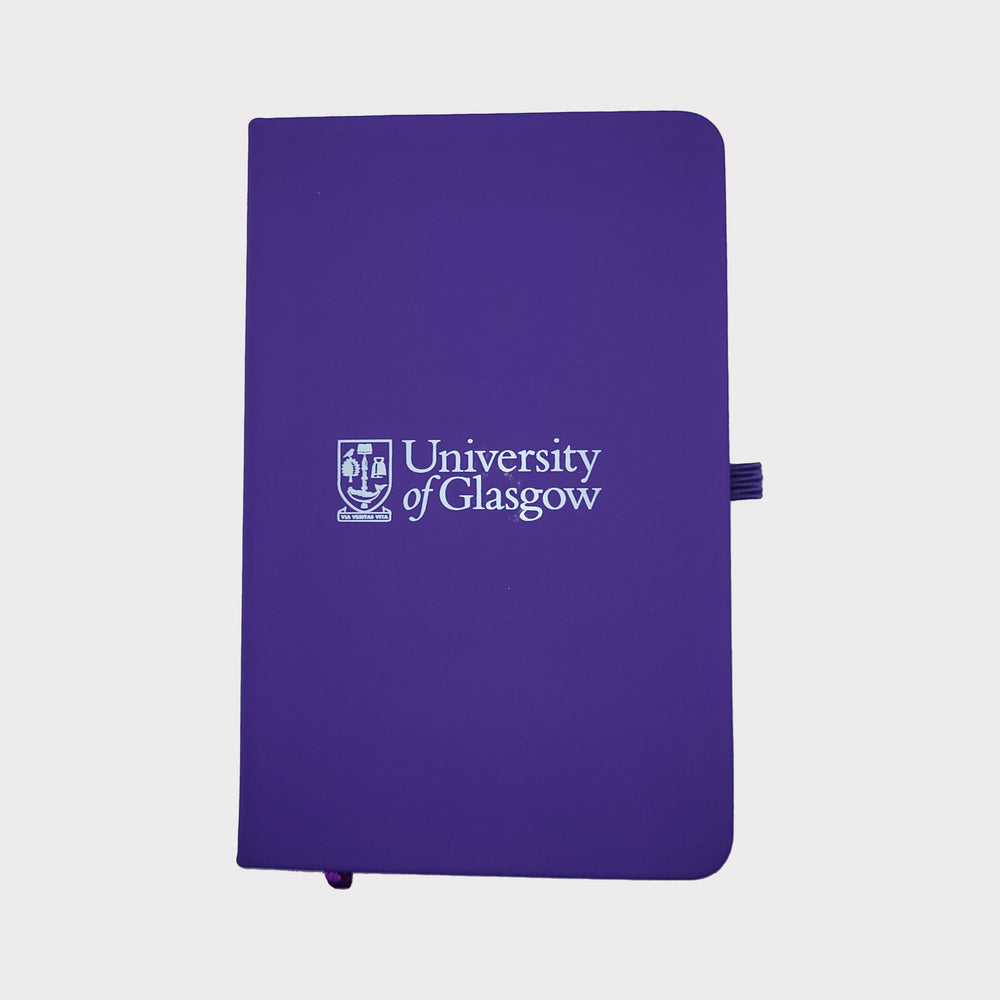 University of Glasgow Purple A6 Pocket Notebook. The UofG crest is printed in white in the centre of the cover. The notebook has a purple closure band and a purple ribbon marker.