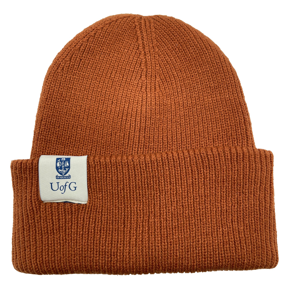 Brown knit beanie with a label on a white background