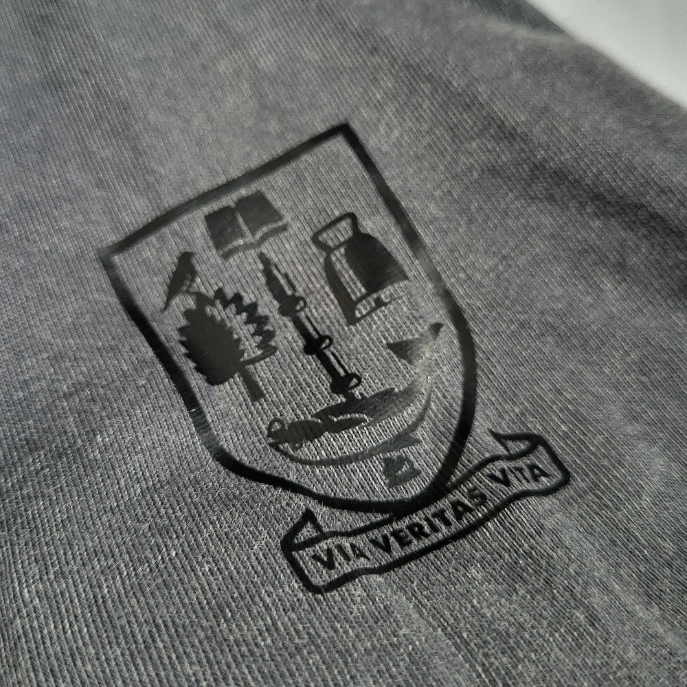 Printed UofG logo on a gray fabric background, sleeve of t-shirt