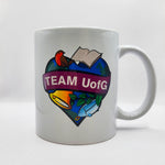 White mug with colorful design and 'TEAM UofG' text on a white background