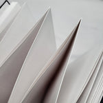 Close-up of white paper with geometric folds on a light gray background