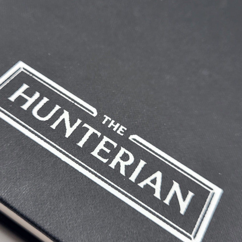 Close-up of 'The Hunterian' logo on a black sketchbook