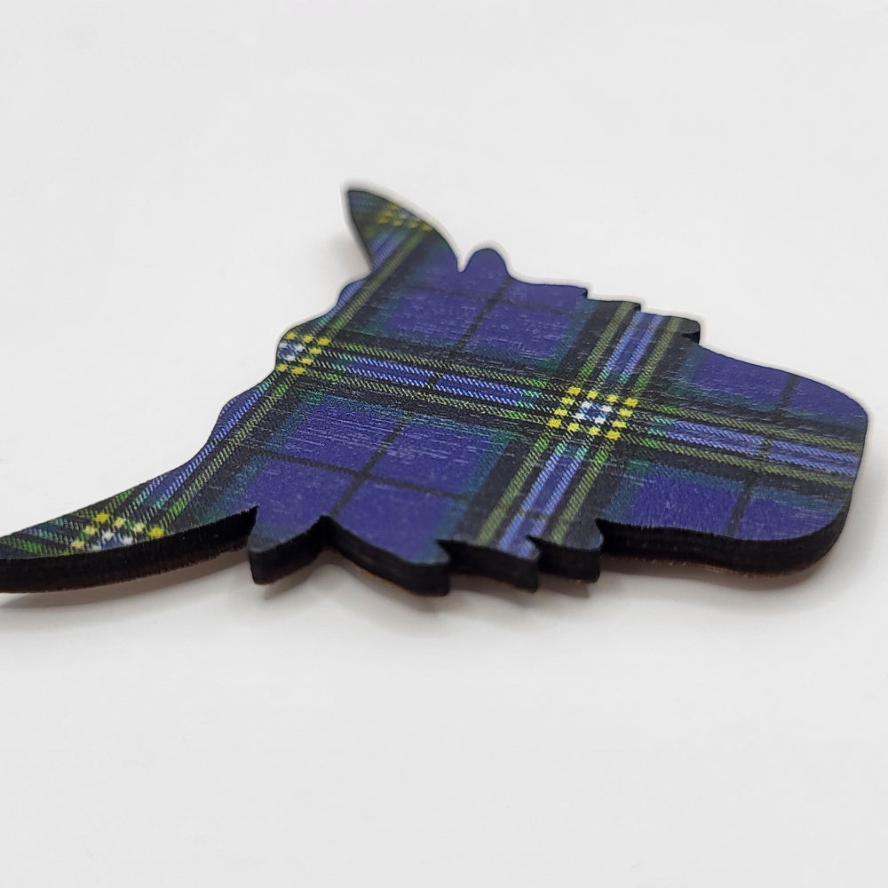 Wooden fridge magnet in the shape of a highland cow's head. The magnet is patterned with the University of Glasgow tartan (side angled view). 
