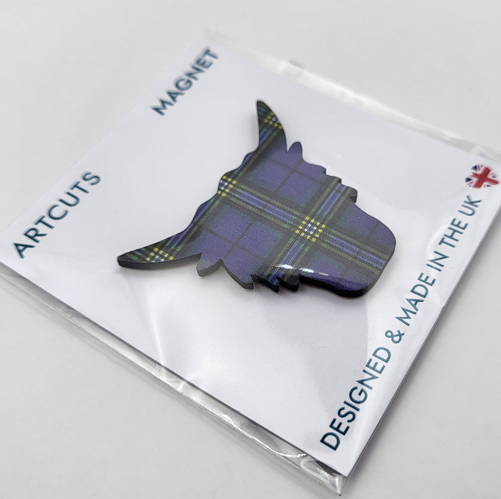 Wooden fridge magnet in packaging. The magnet is in the shape of a highland cow's head, patterned with the University of Glasgow tartan. The packaging is a white backing card with a clear cellophane wrapping. The card reads: "Artcuts Magnet" along the top and "Designed and made in the UK" along the bottom.