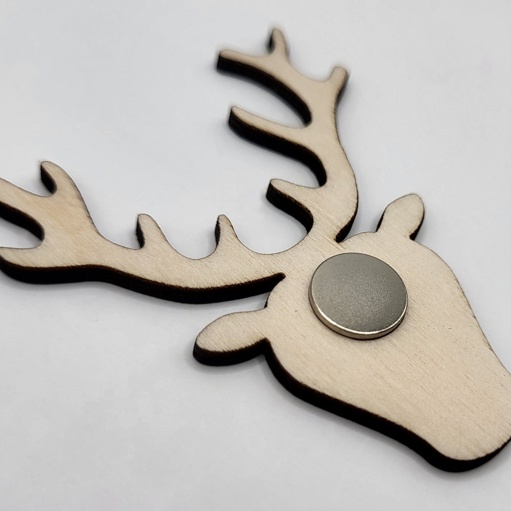 Wooden fridge magnet (reverse view). The magnet is in the shape of a stag's head. The reverse view shows the circular magnet and the unfinished natural wood surface.
