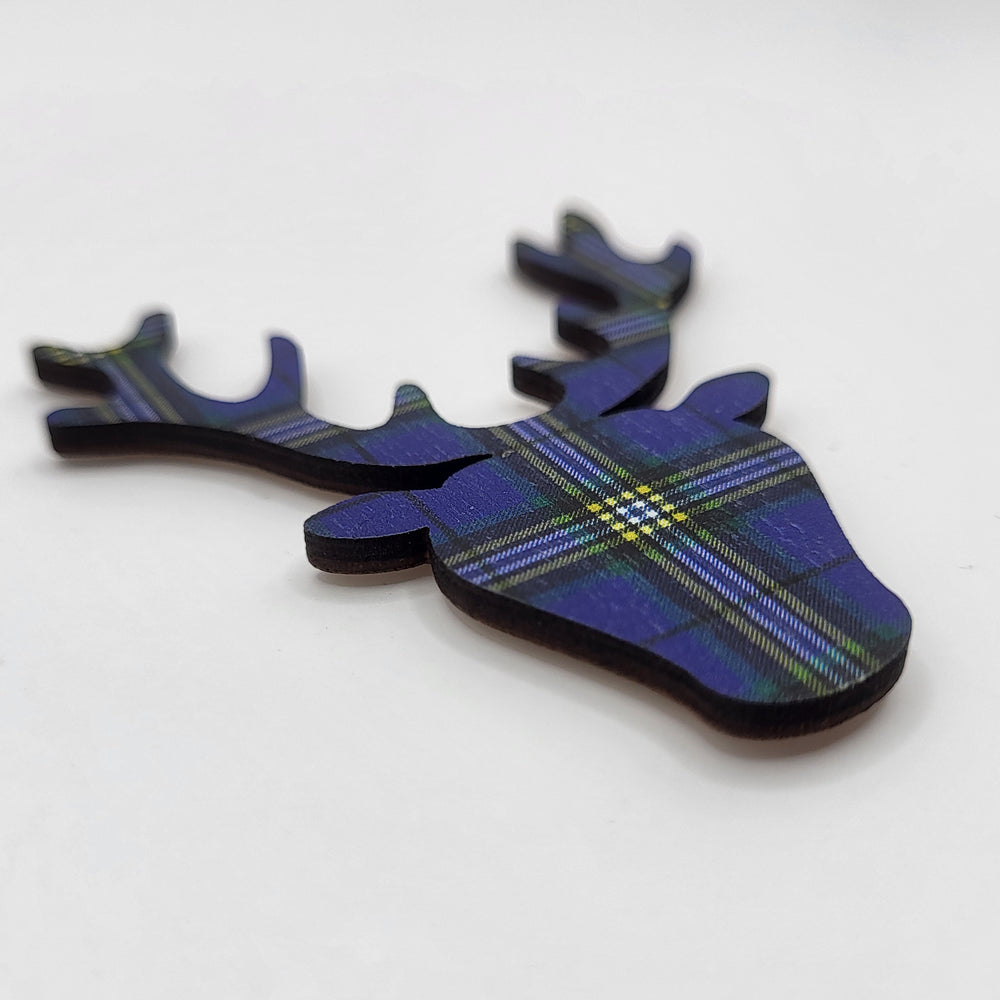Wooden fridge magnet (angled view). The magnet is in the shape of a stag's head and is patterned with the University of Glasgow tartan. 