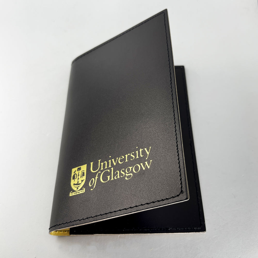 Passport cover (outer sleeve). Plain black with the University of Glasgow crest printed in gold in the lower centre.