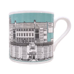 Mackintosh Mug by Illustration, Etc. A light blue mug with a white rim and handle. The mug features a black and white illustration showing famous buildings designed by Charles Rennie Mackintosh.