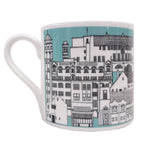 Mackintosh Mug by Illustration, Etc. A light blue mug with a white rim and handle. The mug features a black and white illustration showing famous buildings designed by Charles Rennie Mackintosh.