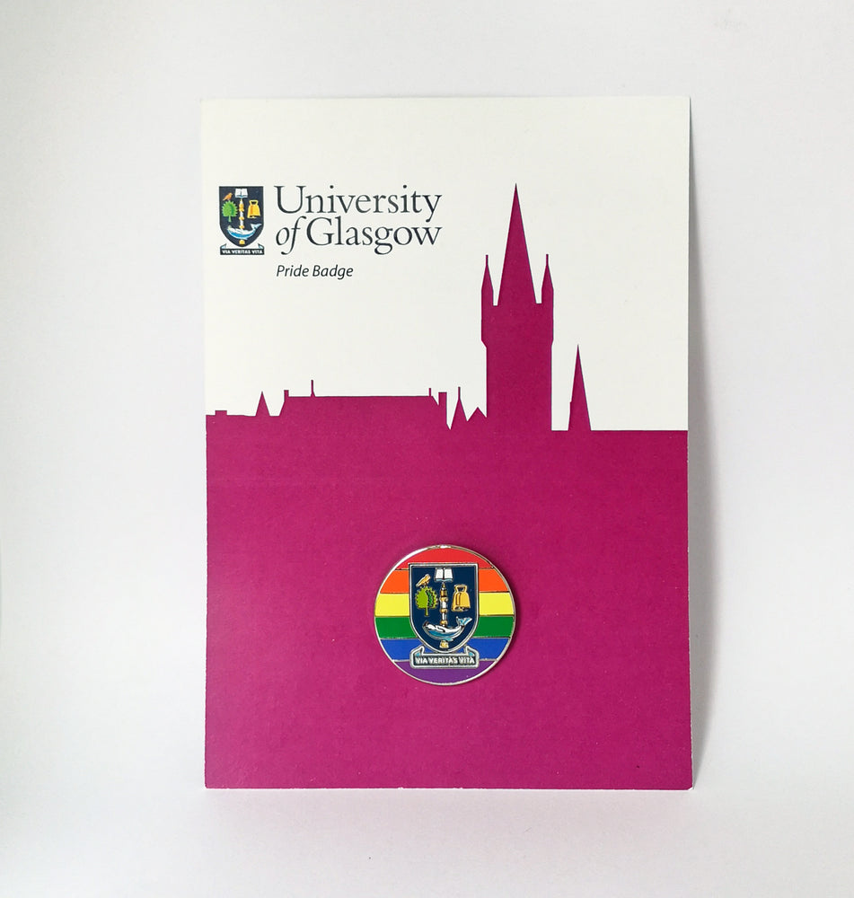 University of Glasgow Pride Pin Badge on backing card. A rainbow enamel pin badge in full colour with the University of Glasgow crest in the centre. The badge is shown displayed on a magenta and white backing card.